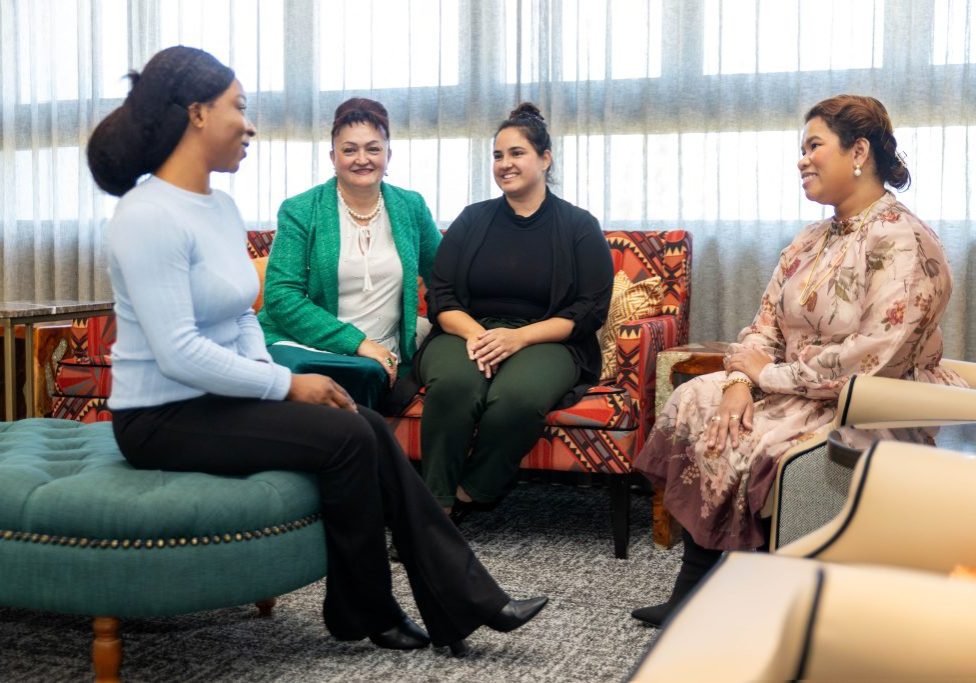 Four women talking to each other.