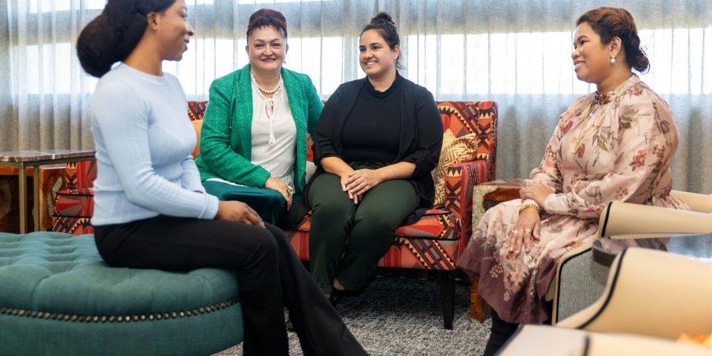 Four women talking to each other.