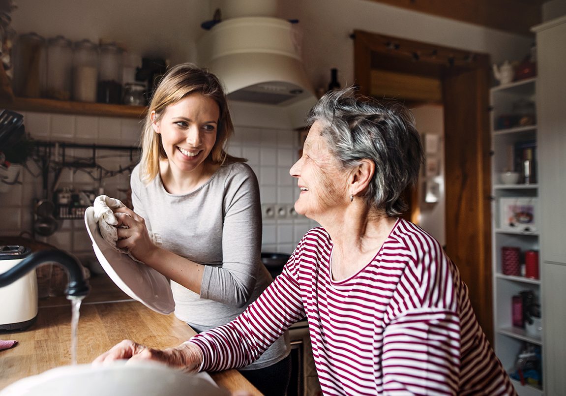 Young and older woman doing the dishes